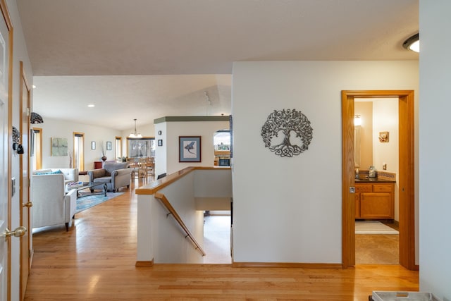 hall featuring light hardwood / wood-style floors and lofted ceiling