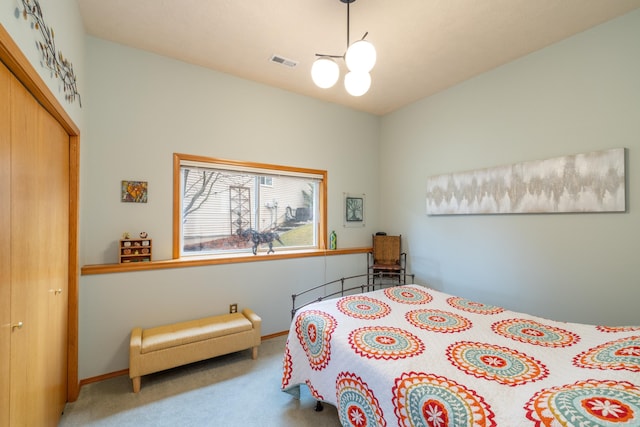 bedroom featuring carpet flooring, a closet, and a notable chandelier