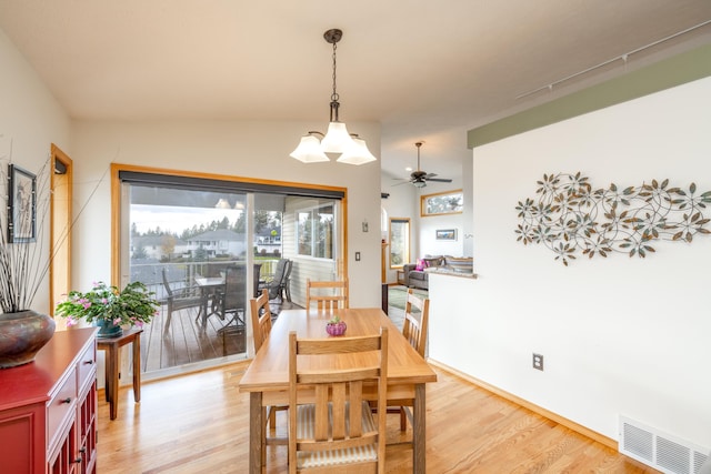 dining space featuring ceiling fan with notable chandelier and light hardwood / wood-style floors