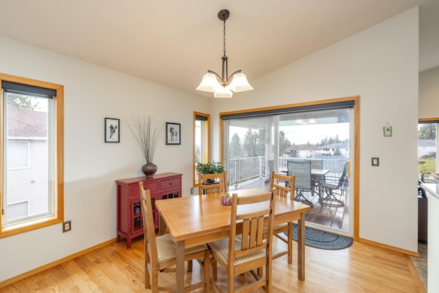 dining room with a healthy amount of sunlight, light hardwood / wood-style flooring, a chandelier, and lofted ceiling