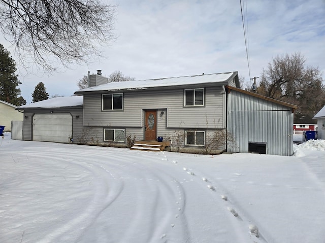 raised ranch featuring a chimney and an attached garage