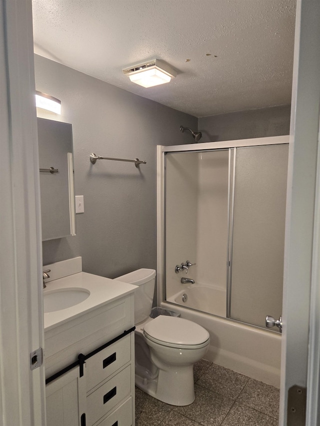 full bathroom featuring combined bath / shower with glass door, toilet, a textured ceiling, and vanity