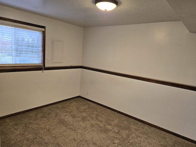 carpeted empty room featuring baseboards and a textured ceiling