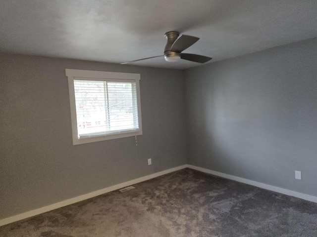 empty room with visible vents, baseboards, dark colored carpet, and ceiling fan