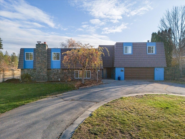 view of front of property featuring a garage and a front lawn