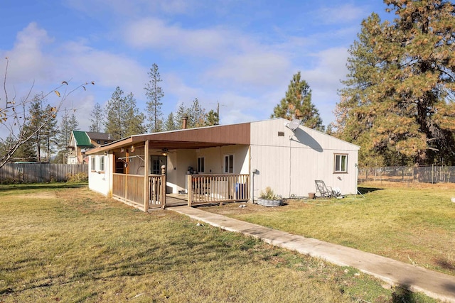 view of front of house with ceiling fan and a front yard