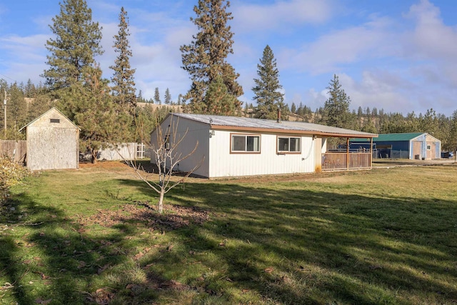 exterior space with metal roof, a shed, an outdoor structure, and a yard