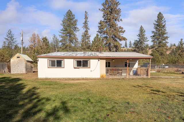 exterior space featuring a wooden deck, ceiling fan, a front yard, and a storage unit