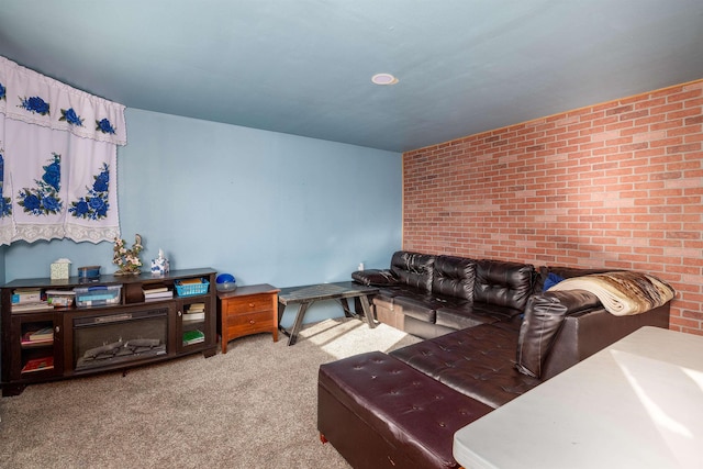 living room with carpet floors and brick wall