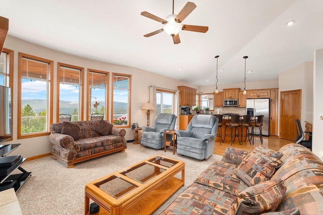 living room with ceiling fan, a mountain view, and lofted ceiling