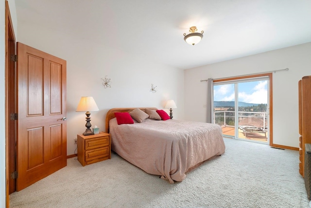 bedroom featuring access to exterior and light carpet