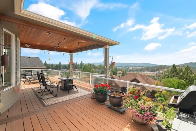 wooden deck with a mountain view and a grill