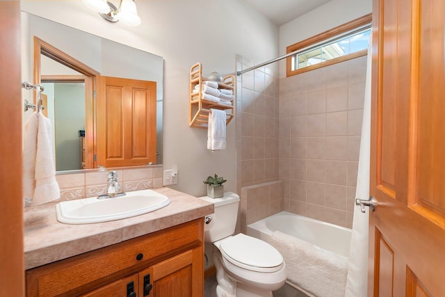 full bathroom with tiled shower / bath combo, toilet, and vanity