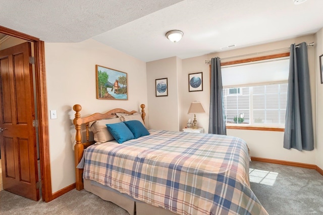 bedroom with a textured ceiling and light colored carpet