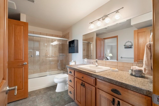 full bathroom featuring vanity, toilet, and shower / bath combination with glass door