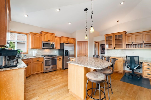 kitchen with backsplash, a center island, a kitchen bar, and stainless steel appliances