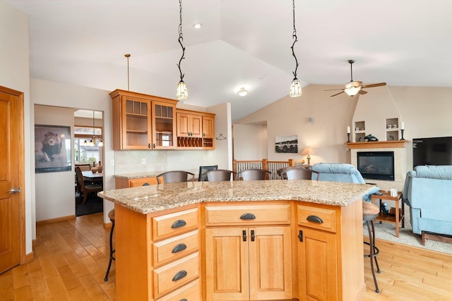 kitchen featuring decorative backsplash, a center island, lofted ceiling, and a breakfast bar area