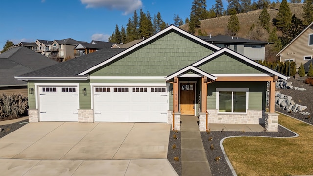 craftsman-style home featuring stone siding, concrete driveway, and an attached garage