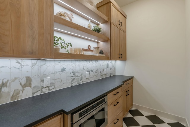 kitchen featuring open shelves, backsplash, dark countertops, and tile patterned floors