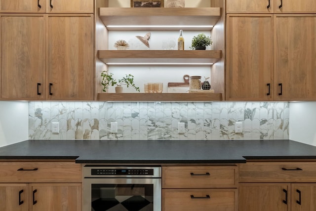 kitchen featuring dark countertops, stainless steel oven, tasteful backsplash, and open shelves