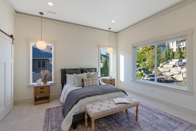 bedroom with a barn door, ornamental molding, baseboards, and light carpet