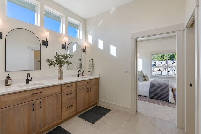 full bath featuring double vanity, tile patterned flooring, ensuite bath, and a sink