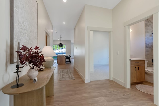 hallway featuring recessed lighting, light wood-type flooring, and baseboards