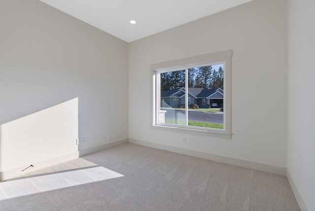 carpeted empty room featuring recessed lighting and baseboards