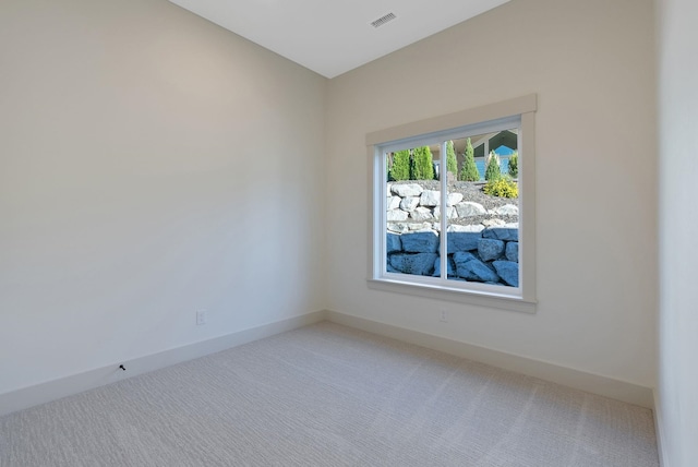 spare room featuring visible vents, baseboards, and light colored carpet