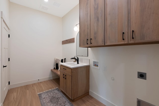 washroom with visible vents, washer hookup, a sink, cabinet space, and hookup for an electric dryer