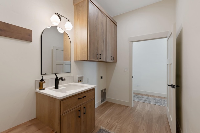 bathroom featuring vanity, wood finished floors, and baseboards