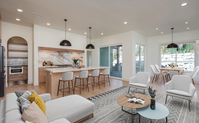 living area featuring recessed lighting, light wood-style floors, and visible vents