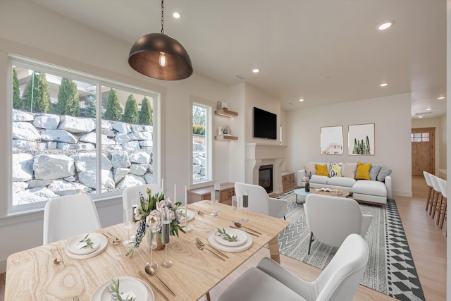 dining space featuring a wealth of natural light, a glass covered fireplace, and recessed lighting