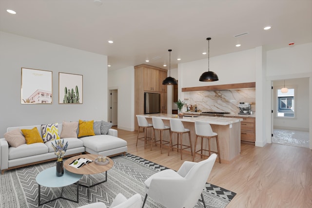 living room featuring light wood finished floors, visible vents, and recessed lighting