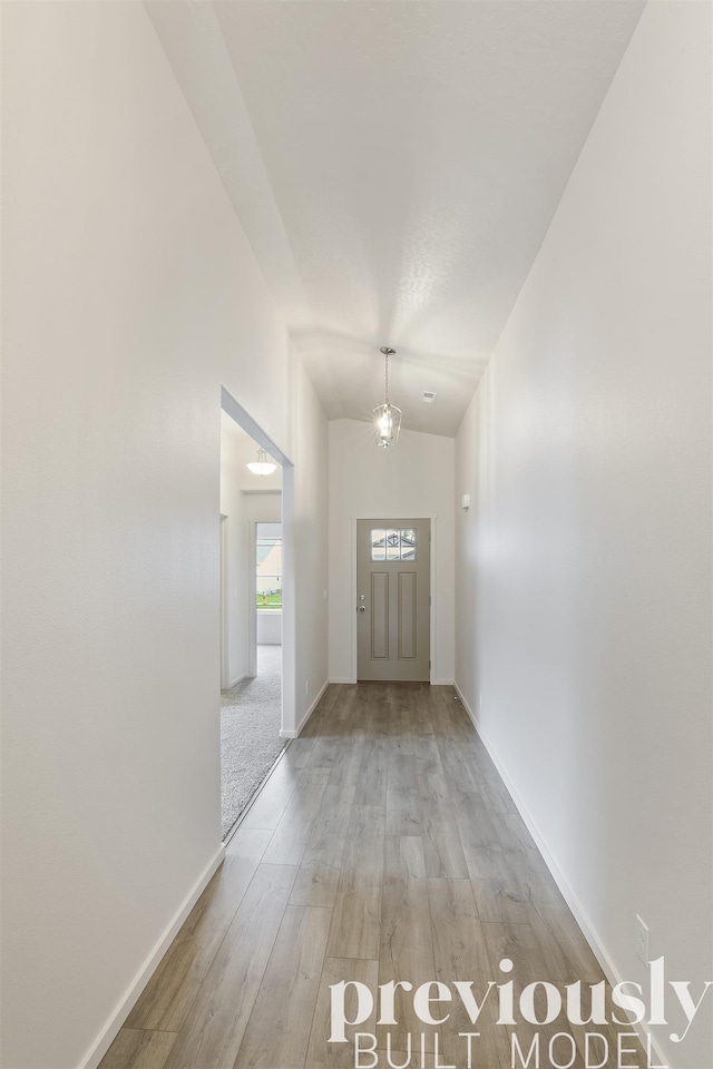 interior space featuring lofted ceiling and light wood-type flooring