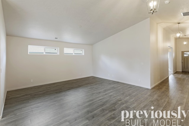 unfurnished room featuring dark hardwood / wood-style floors and a notable chandelier