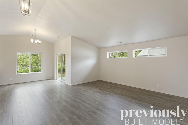 empty room featuring a notable chandelier, dark hardwood / wood-style flooring, lofted ceiling, and a textured ceiling