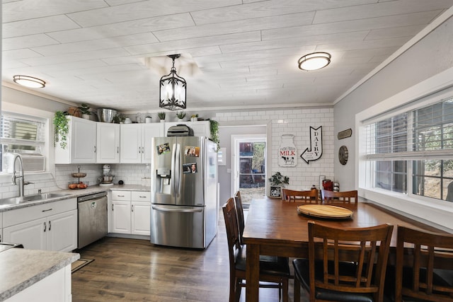 kitchen with dark wood-type flooring, crown molding, sink, white cabinetry, and stainless steel appliances