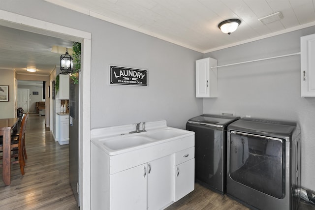 laundry area featuring cabinets, sink, separate washer and dryer, ornamental molding, and dark hardwood / wood-style flooring