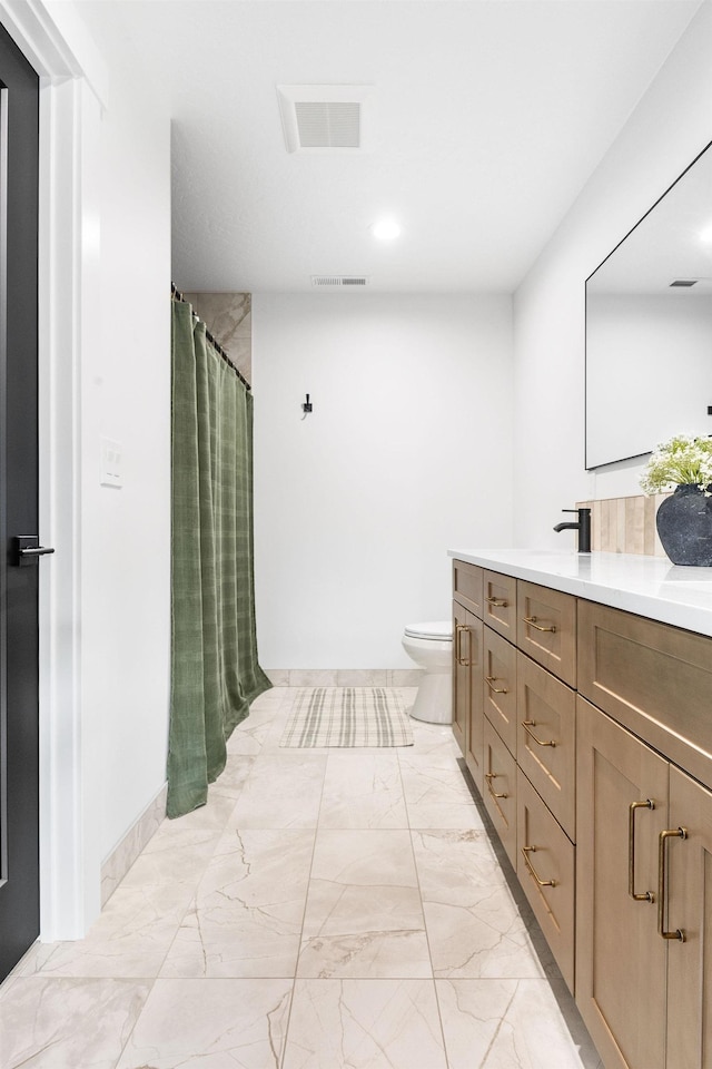 bathroom featuring vanity, toilet, and walk in shower