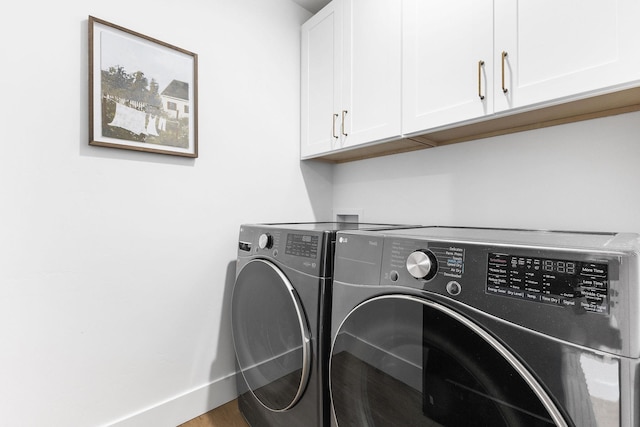 clothes washing area with cabinets, wood-type flooring, and separate washer and dryer