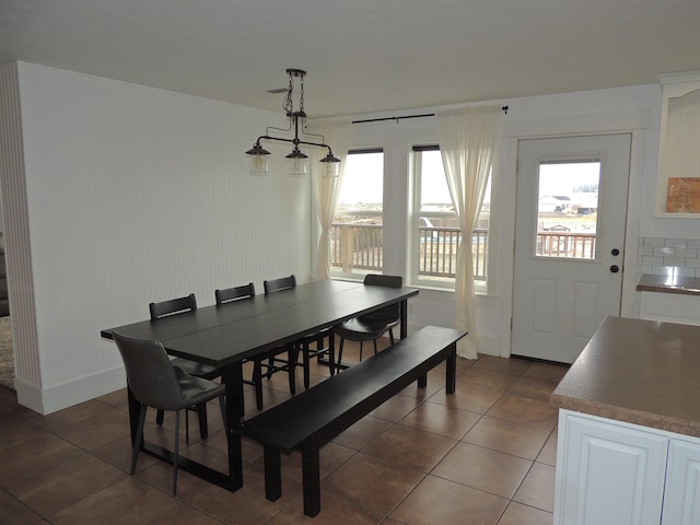 dining space featuring dark tile patterned floors