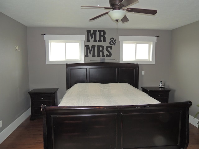 bedroom featuring multiple windows, dark hardwood / wood-style flooring, and ceiling fan