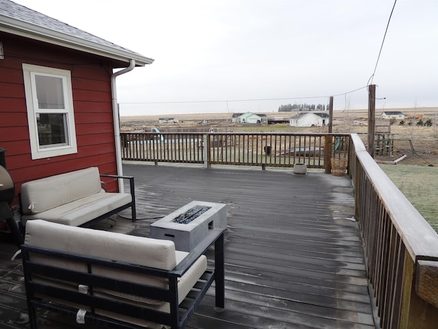 deck featuring an outdoor living space with a fire pit