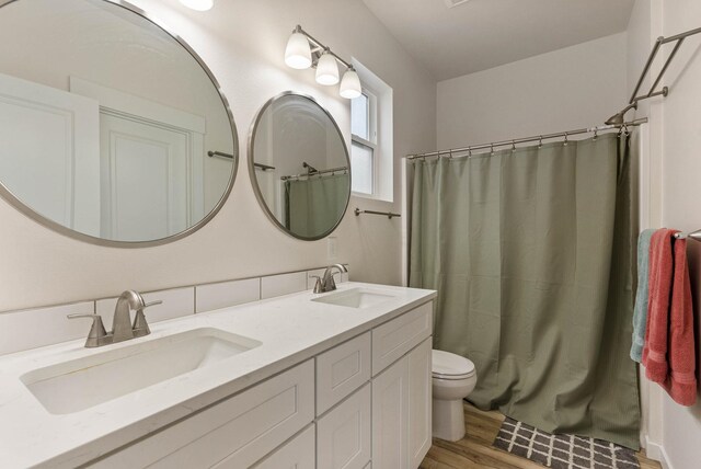 bathroom featuring vanity, hardwood / wood-style flooring, and toilet