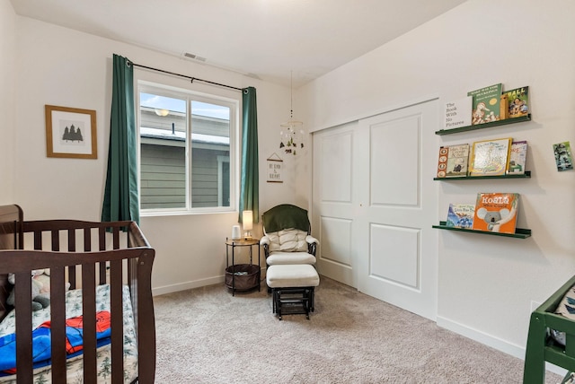 bedroom featuring carpet, a crib, and a closet