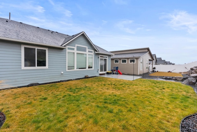 rear view of property with an outdoor structure, a patio area, and a yard