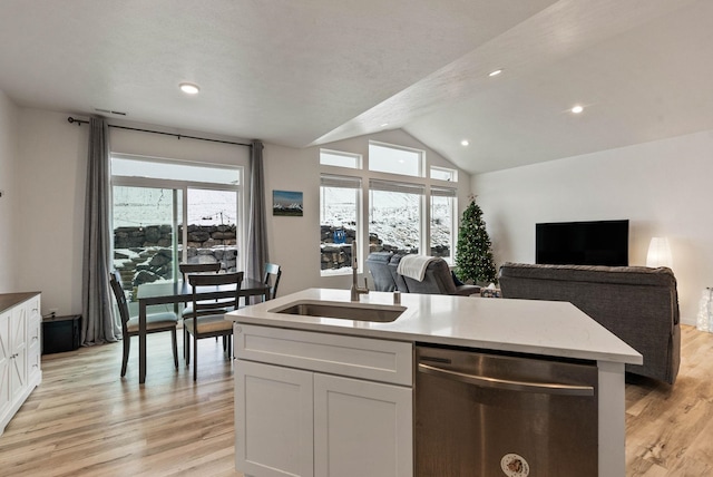 kitchen with white cabinets, light wood-type flooring, stainless steel dishwasher, and sink