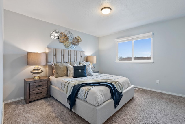 bedroom featuring a textured ceiling and light colored carpet