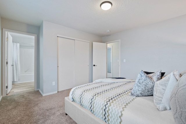 bedroom with light carpet, a textured ceiling, connected bathroom, and a closet